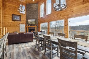 a dining room with a table and chairs and a fireplace at Wild Heart Lodge cabin in Sevierville