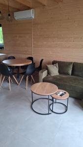 een woonkamer met 2 tafels en een bank bij Domki Morskie Jastrzębia Góra - Domki z basenem in Jastrzębia Góra +56 foto's