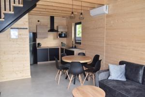 Una cocina y una sala de estar con mesa y sillas. en Domki Morskie Jastrzębia Góra - Domki z basenem, en Jastrzębia Góra