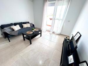 a living room with a blue couch and a table at Apartamento Empul Rota Príncipe in Rota