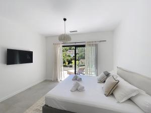 Un dormitorio blanco con una cama grande y un televisor. en Villa Manon, en Le Rouret 51 fotos más