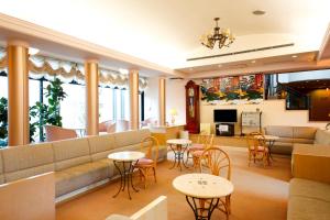 a lobby with a couch and tables and chairs at Amanohashidateso in Miyazu