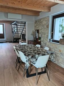 a dining room with a table and white chairs at casa del corso 27 in Sirolo