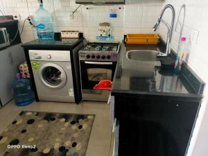 a kitchen with a stove and a washing machine at بنتهاوس الأحلام بإطلالة أكوا بارك 4 غرف لقطة in El Alamein