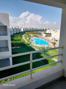 a balcony with a view of a swimming pool at بنتهاوس الأحلام بإطلالة أكوا بارك 4 غرف لقطة in El Alamein