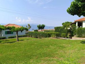 a yard with green grass and a house at Verde e Mare apartments-Marathias in Marathias