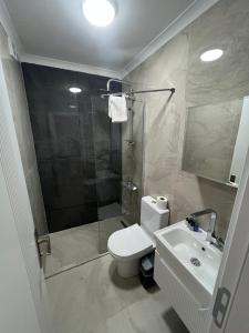 een badkamer met douche, toilet en wastafel bij Çam Otel in Edremit