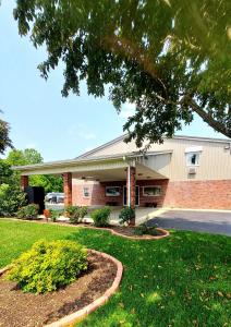 a large brick building with a lawn in front of it at PATRIOT INN in Spencer