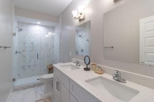 une salle de bain blanche avec deux lavabos et une douche dans l'établissement Modern & Spacious 3bd 3ba RoofDeck, à Washington 23 autres photos