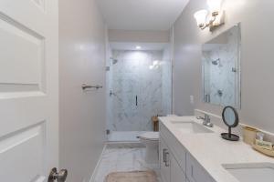 a white bathroom with a shower and a toilet at Modern & Spacious 3bd 3ba RoofDeck in Washington +16 photos