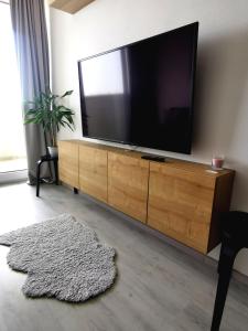 a living room with a flat screen tv on a wooden cabinet at MATADOR apartment & Free Parking in Bratislava
