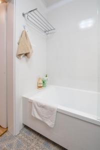 a white bathroom with a sink and a towel at Green Apartment Chrzanów in Chrzanów