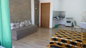 a living room with a couch and a kitchen at Studio na Serra I in Itatiaia