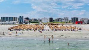 a beach with a group of people on the beach at MiMar Apartment in Năvodari