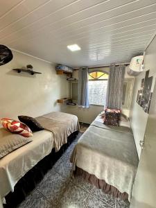 a bedroom with two beds and a window in it at Linda e Ampla Casa Inteira Próxima ao Centro de Criciúma in Criciúma +110 photos