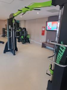 einen Fitnessraum mit Reihen von Laufbändern und einem Flachbild-TV in der Unterkunft Enjoy Olimpia Park Resorts ! in Olímpia