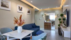 Una sala de estar con un sofá azul y una mesa. en R&S Marina Bay Tanger Marsa, en Tánger