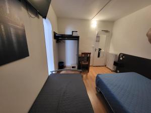 a small room with a bed and a chair at Hotel Les Rosiers in La Rochelle