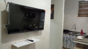 a television hanging on a wall in a bathroom at Apartamento Completo e Centralizado 4 in Belém