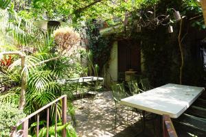 a patio with a table and chairs in a garden at Enjoy AC in Our Guest Room at Inn Ajijic in Ajijic