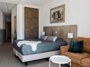 a bedroom with a bed and a couch at Seaside Double Duyn Suites in Callantsoog