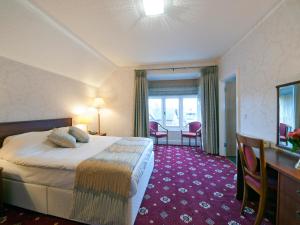 a hotel room with a bed and a table and chairs at Brambletye Hotel in Forest Row