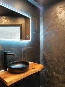 a bathroom with a black sink and a mirror at Feinwald Highline Altenau in Altenau +25 photos