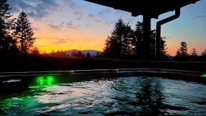 een zwembad met een zonsondergang op de achtergrond bij Hytta Eliaszówka in Piwniczna
