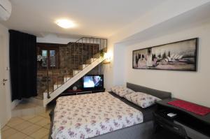a small bedroom with a bed and a staircase at Holiday House - Bella Nicol in Koper +5 photos
