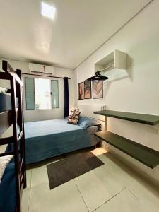 a small bedroom with a bed and a window at Casas CostaMar in Caraguatatuba +43 photos