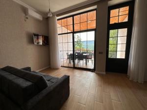 a living room with a couch and a large glass door at Luxury villa with a view in Quba