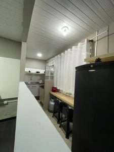 a large kitchen with a counter and chairs in it at Apartamento 05 - Um quarto, sala e cozinha in Balneário Camboriú +2 photos