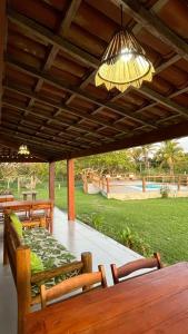 un patio con tavolo, sedie e lampadario pendente di Vila das Mangabeiras Corumbau a Corumbau Altre 101 foto
