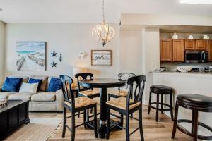 een keuken en woonkamer met een tafel en stoelen bij Sunrise Beach 906 -Beachfront Condo in Panama City Beach
