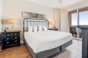 een slaapkamer met een groot bed en een balkon bij Sunrise Beach 906 -Beachfront Condo in Panama City Beach