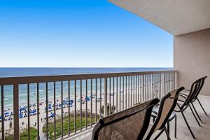 een balkon met 2 stoelen en uitzicht op het strand bij Sunrise Beach 906 -Beachfront Condo in Panama City Beach +48 foto's