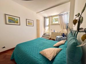 Un dormitorio con una cama verde y una ventana. en La Piccola Mimosa, en Sestri Levante