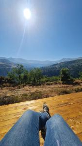 una persona seduta su un pavimento di legno con il sole nel cielo di Teffeha tent for 2 