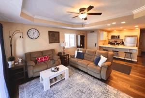 een woonkamer met twee banken en een klok aan de muur bij Lakeview Lake Ozark Condo 2bd2bapool-sleeps 7pp in Lake Ozark
