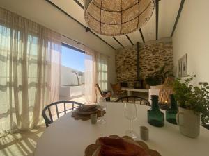 a dining room with a table and a large window at Casa Amanhada Apartamento Zero in Grândola