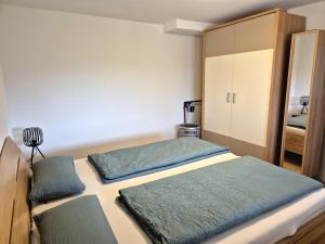 a bedroom with two beds and a cabinet at Ferienwohnung Ankerplatz in Schluchsee