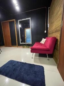 un soggiorno con divano rosso e tappeto blu di Suíte com Hidro no centro a Balneário Camboriú