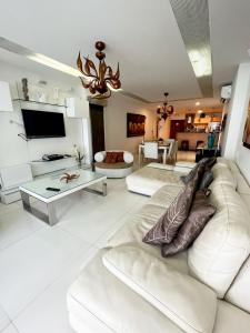 un salon avec un canapé blanc et une télévision dans l'établissement Sunrise vista al mar!, à San Andrés 17 autres photos