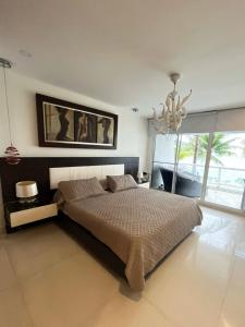 une chambre avec un grand lit et un lustre dans l'établissement Sunrise vista al mar!, à San Andrés