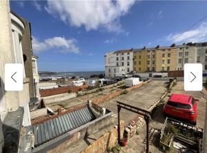 a red car parked in a parking lot next to a building at Inspiro house4 in Scarborough
