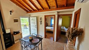 a dining room with a table and chairs and a bedroom at Lithos Haven in Agía Paraskeví