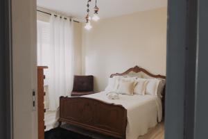 a bedroom with a large bed and a chair at Apartamento amplo in Pelotas