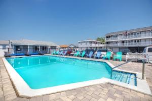 a swimming pool with chairs and a hotel at Marguerite Motel in Hampton