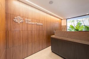 a hotel entrance with a sign on a wooden wall at Hotel Trianon Paulista in Sao Paulo +37 photos