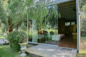 帕查卡马克Elegant 5BR with Garden view Home in Cieneguilla的木制甲板上放着花瓶的玻璃房子